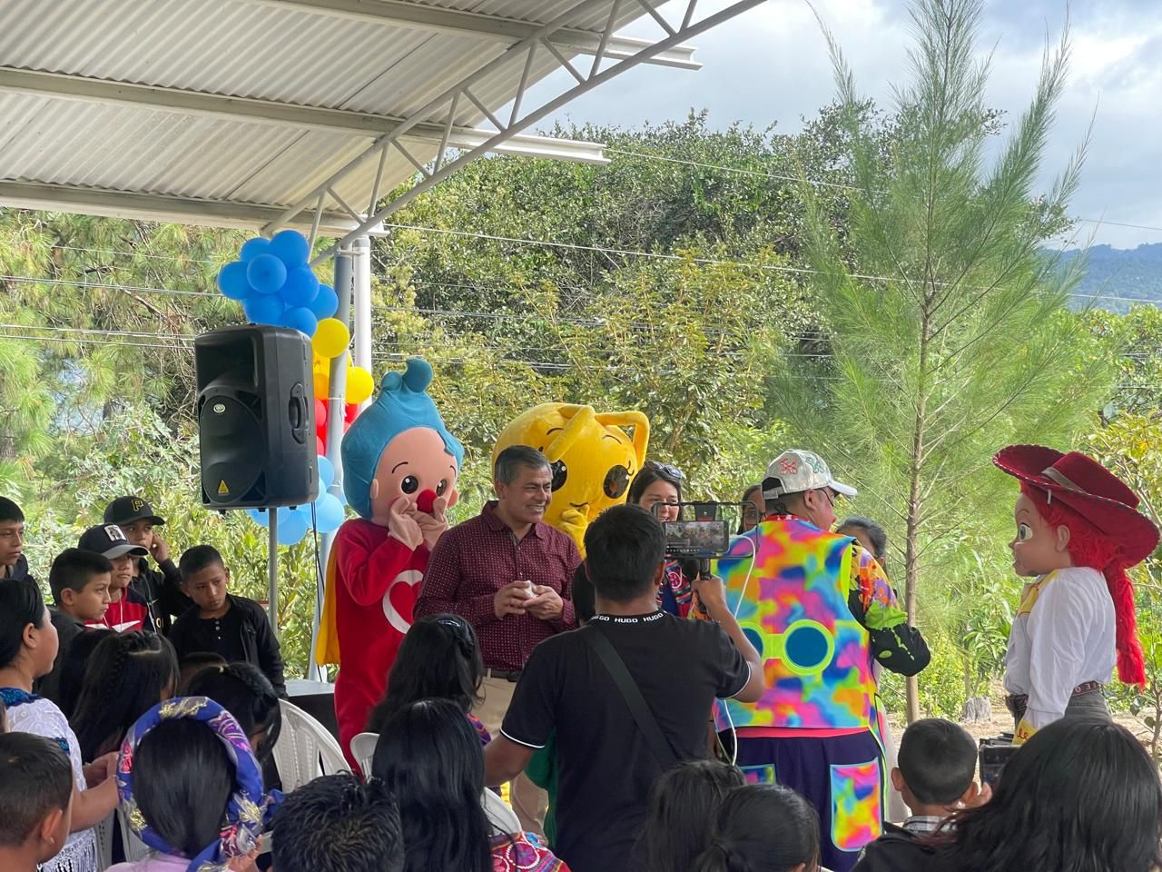 A clown with smiling children at a Kuxaj event